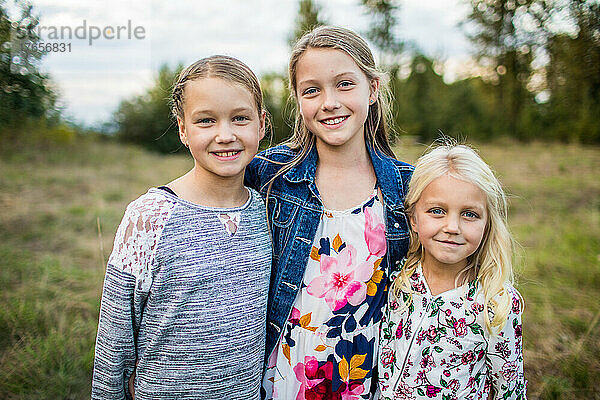 Außenporträt von drei schönen jungen Mädchen  Schwestern.