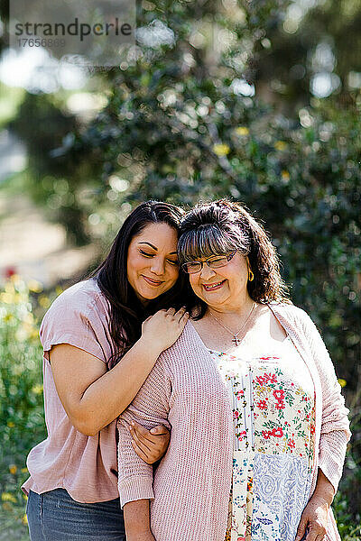 Mutter und Tochter umarmen sich im Park in San Diego
