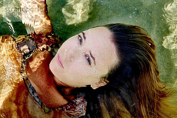 Porträt eines Mädchens mit offenen Augen unter Wasser