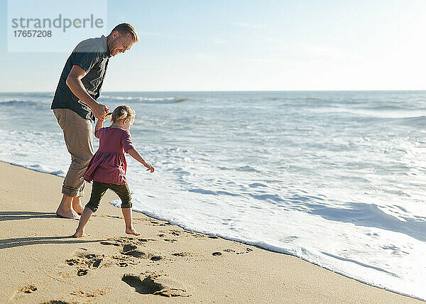 Vater und Tochter spielen am Strand