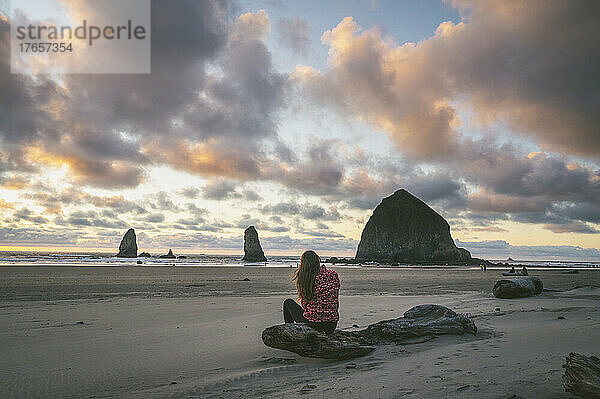 Weibchen beobachten den Sonnenuntergang am Haystack Rock an der Küste von Oregon
