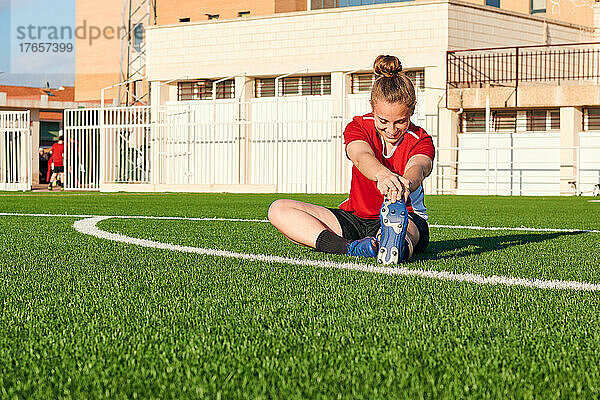 Eine Fußballspielerin dehnt sich während einer Trainingseinheit