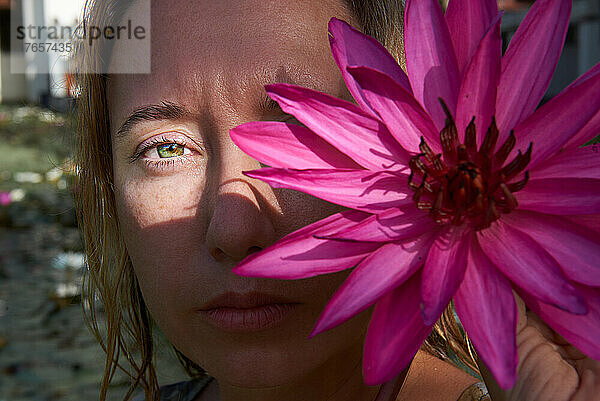 Porträt eines Mädchens mit einer Blume auf der Hälfte ihres Gesichts
