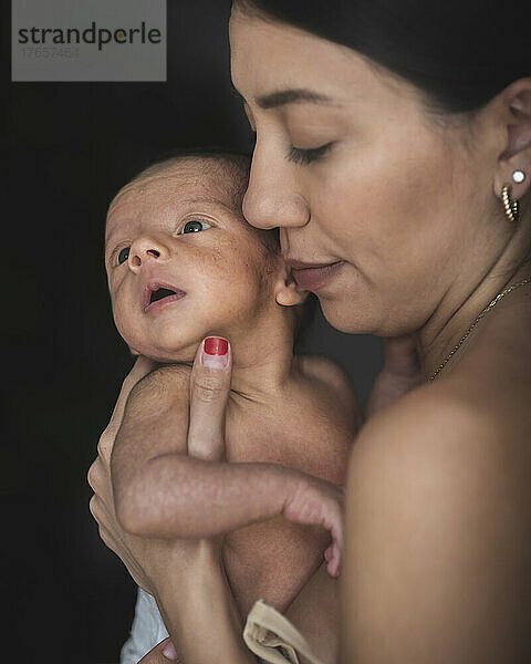 Lateinamerikanische Mutter mit ihrem süßen Neugeborenen