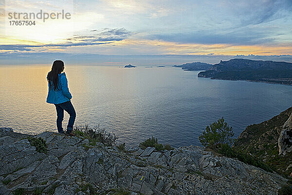 Frau steht auf einer Klippe an der französischen Côte d'Azur