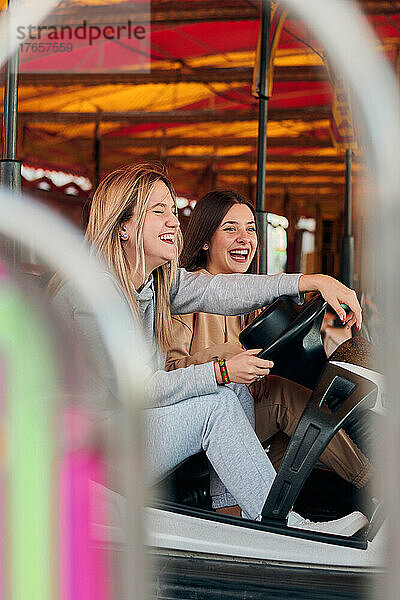 Zwei junge Frauen haben Spaß beim Autoscooterfahren