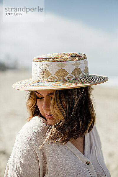 Frau aus der Mitte der dreißiger Jahre mit gemischter Abstammung modelliert Hut und Kleidung in San Diego