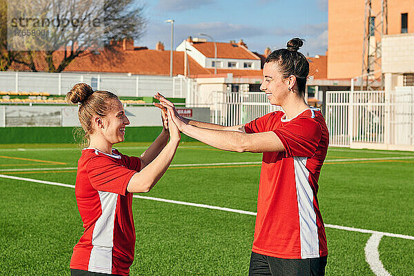 Zwei Fußballspielerinnen geben sich während eines Fußballspiels gegenseitig ein High-Five