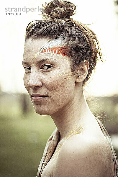 Alternative junge starke Frau mit Stammes-Gesichtsbemalung