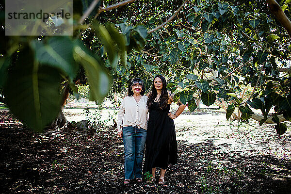 Mutter und Tochter posieren zwischen Bäumen in San Diego