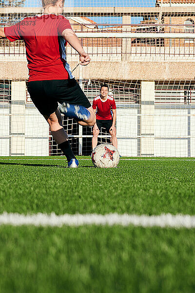 Eine Fußballspielerin gibt ihrem Teamkollegen einen Elfmeter