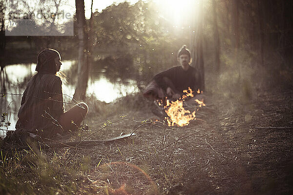 Feuer am Wasser mit Freunden am Frühlingsnachmittag