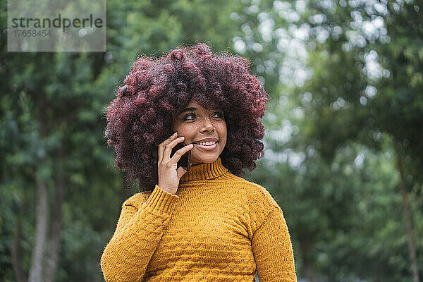 Junge Afro-Frau telefoniert mit ihrem Handy im Freien.