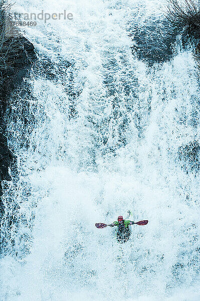 Athletischer Mann beim Kajakfahren im Wildwasser