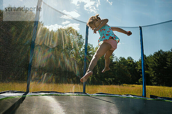 Mädchen springt in der Luft auf Trampolin
