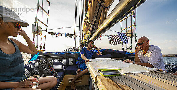 Taucher an Deck eines Segelbootes planen eine Kreuzfahrt rund um die Insel Komodo