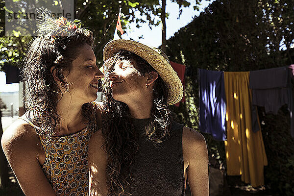 Zwei queere Frauen umarmen sich auf einem Sommercampingplatz innig