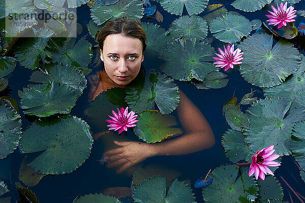schönes Mädchen im See mit Lotusblumen