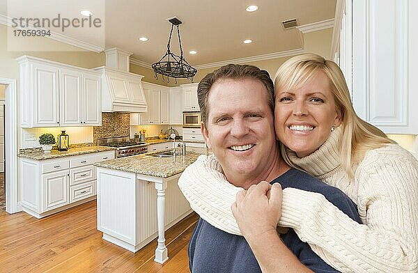 Ein glückliches Paar umarmt sich in einer schönen  maßgeschneiderten Küche