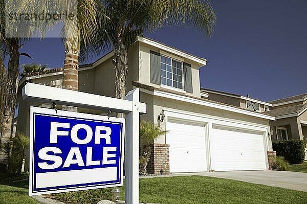 Blaues Schild Immobilien zu verkaufen vor dem Haus