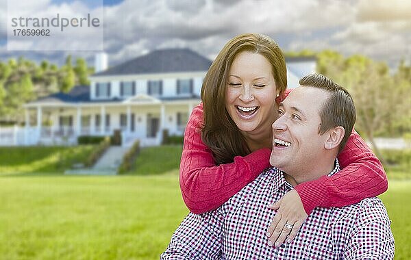 Glückliches  zärtliches  lachendes Paar im Freien vor einem schönen Haus