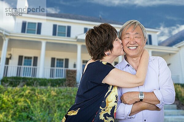 Glückliche chinesische ältere erwachsene Paar küssen vor der benutzerdefinierten Haus
