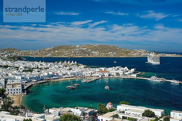 View of Mykonos town Greek tourist holiday vacation destination with famous windmills  and port with boats and yachts and cruise liner. Mykonos  Cyclades islands  Greece