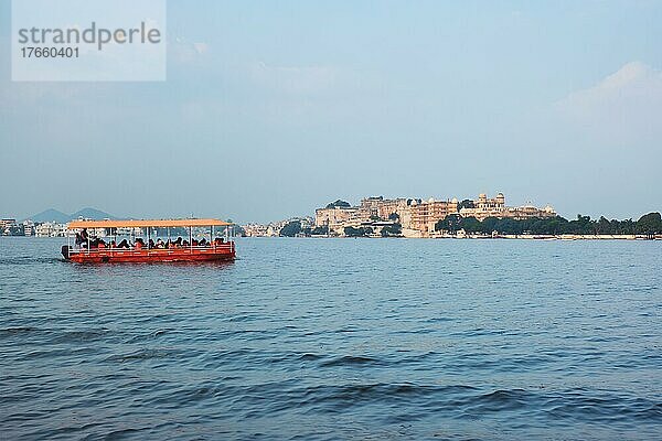 Toruist boat in Lake Pichola with City Palace in background. Udaipur  Rajasthan  India