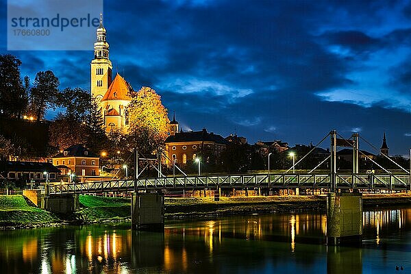 Salzburg night view  Leprosenhauskirche church and Mullner Steg bridge illuminated at night. Salzburg  Austria