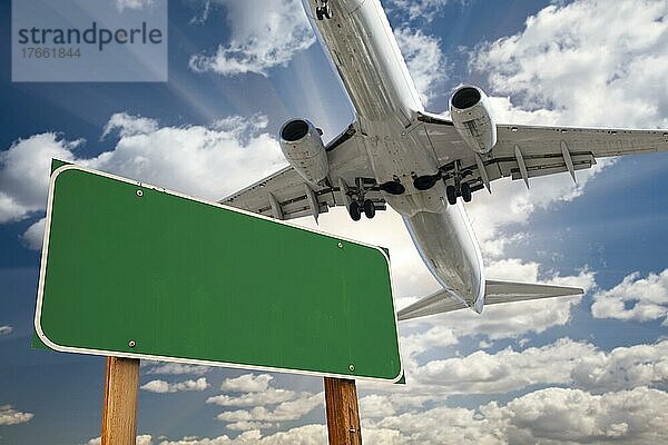 Leeres grünes Straßenschild und Flugzeug über mit dramatischen blauen Himmel und Wolken