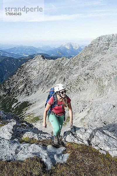 Wanderin mit Kletterhelm auf einem Wanderweg  Berglandschaft  Nuaracher Höhenweg  Loferer Steinberge  Tirol  Österreich  Europa