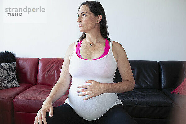 Serene schwangere Frau in Tank Top berühren Babybauch