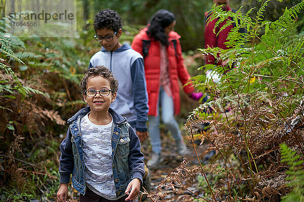 Porträt niedlichen Jungen Wandern mit Familie auf dem Weg in den Wald