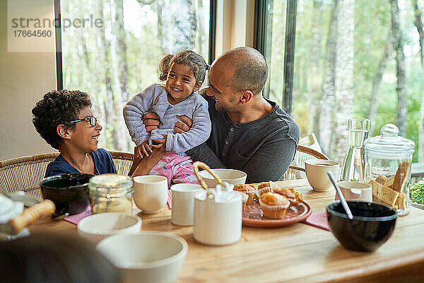 Glücklicher Vater und Kinder beim Essen am Esstisch