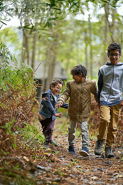 Glückliche Brüder wandern auf einem Pfad im Wald