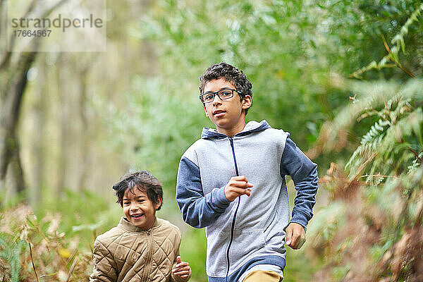 Brüder rennen zusammen im Wald