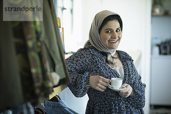 Porträt einer selbstbewussten jungen Muslimin im Hidschab  die Kaffee trinkt