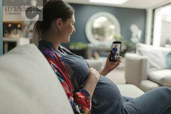 Schwangere Frau im Video-Chat mit Arzt auf Smartphone