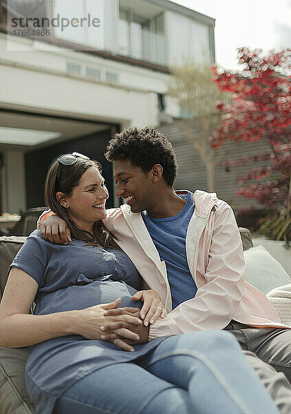 Glückliches  liebevolles  schwangeres Paar auf der Terrasse
