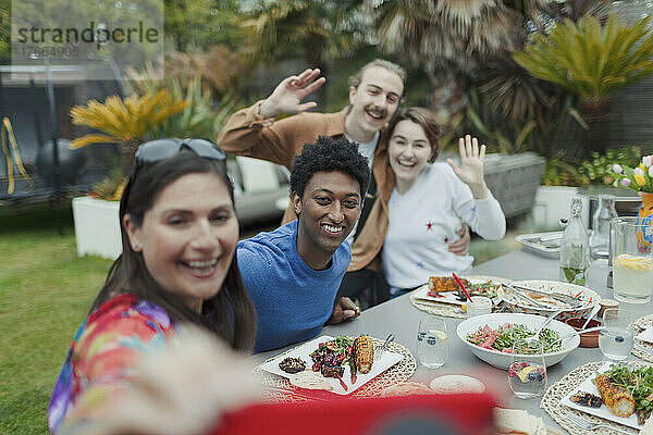 Glückliche Paare machen ein Selfie am Mittagstisch auf der Terrasse