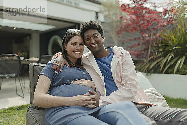 Porträt glückliches schwangeres Paar auf Veranda