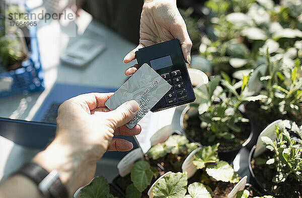 Nahaufnahme eines Kunden  der mit einer Chipkarte für Pflanzen bezahlt