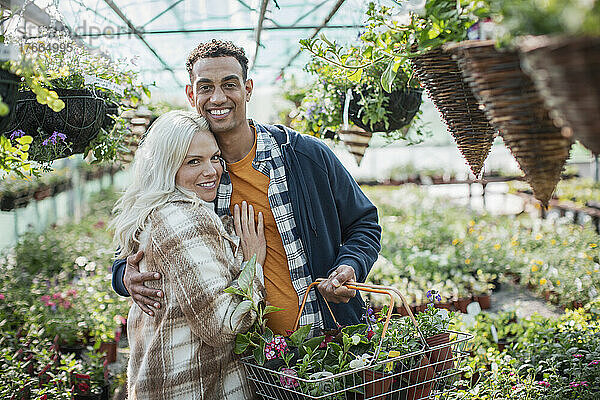 Porträt glückliches Paar beim Einkaufen von Blumen im Gewächshaus