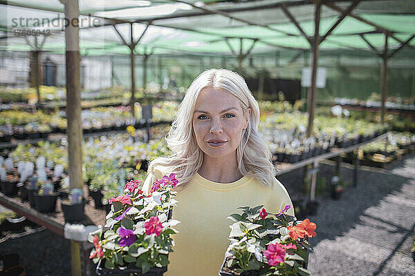 Porträt einer Frau beim Einkaufen von Topfblumen in einem Gartengeschäft