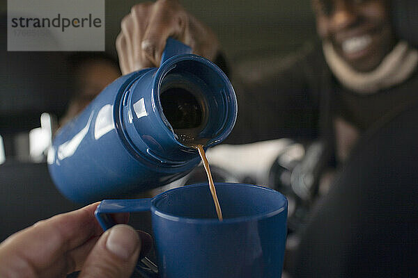 POV Nahaufnahme Mann gießt Kaffee aus Thermoskanne in Tasse