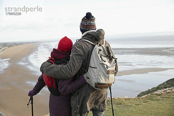 Zärtliches Wandererpaar auf Klippe mit Meerblick