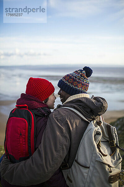 Zärtliches Wandererpaar mit Rucksäcken  die sich umarmen