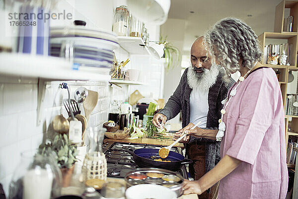 Älteres Paar kocht am Küchenherd
