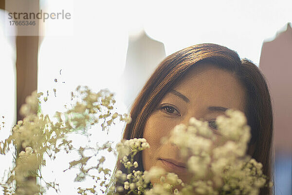 Nahaufnahme einer Frau mit Blick auf weiße Blumen