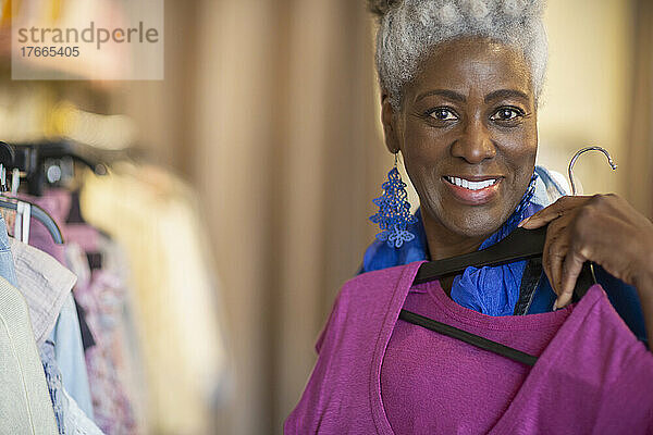 Porträt glückliche selbstbewusste ältere Frau beim Einkaufen in einem Bekleidungsgeschäft